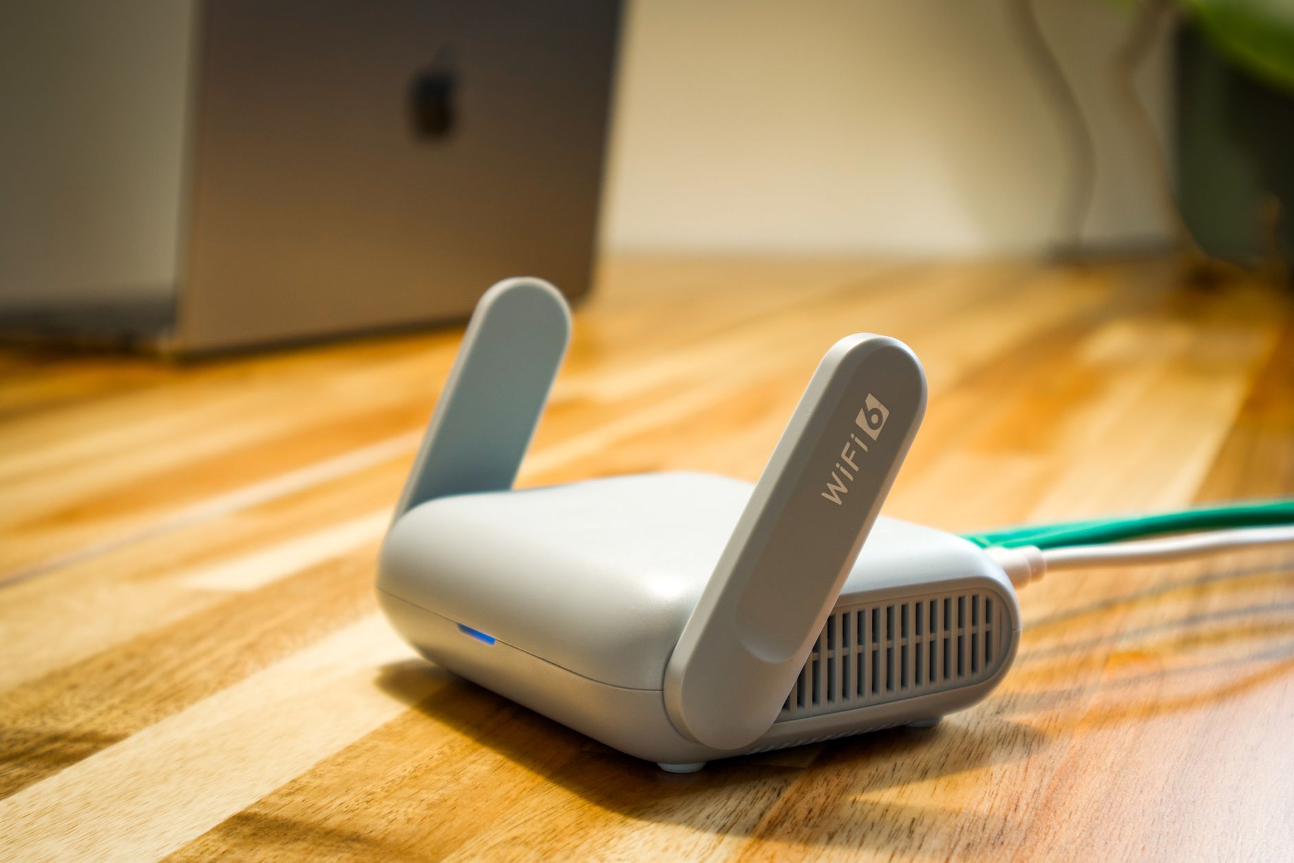 Ahşap bir masanın üzerinde antenli modern bir WiFi modem