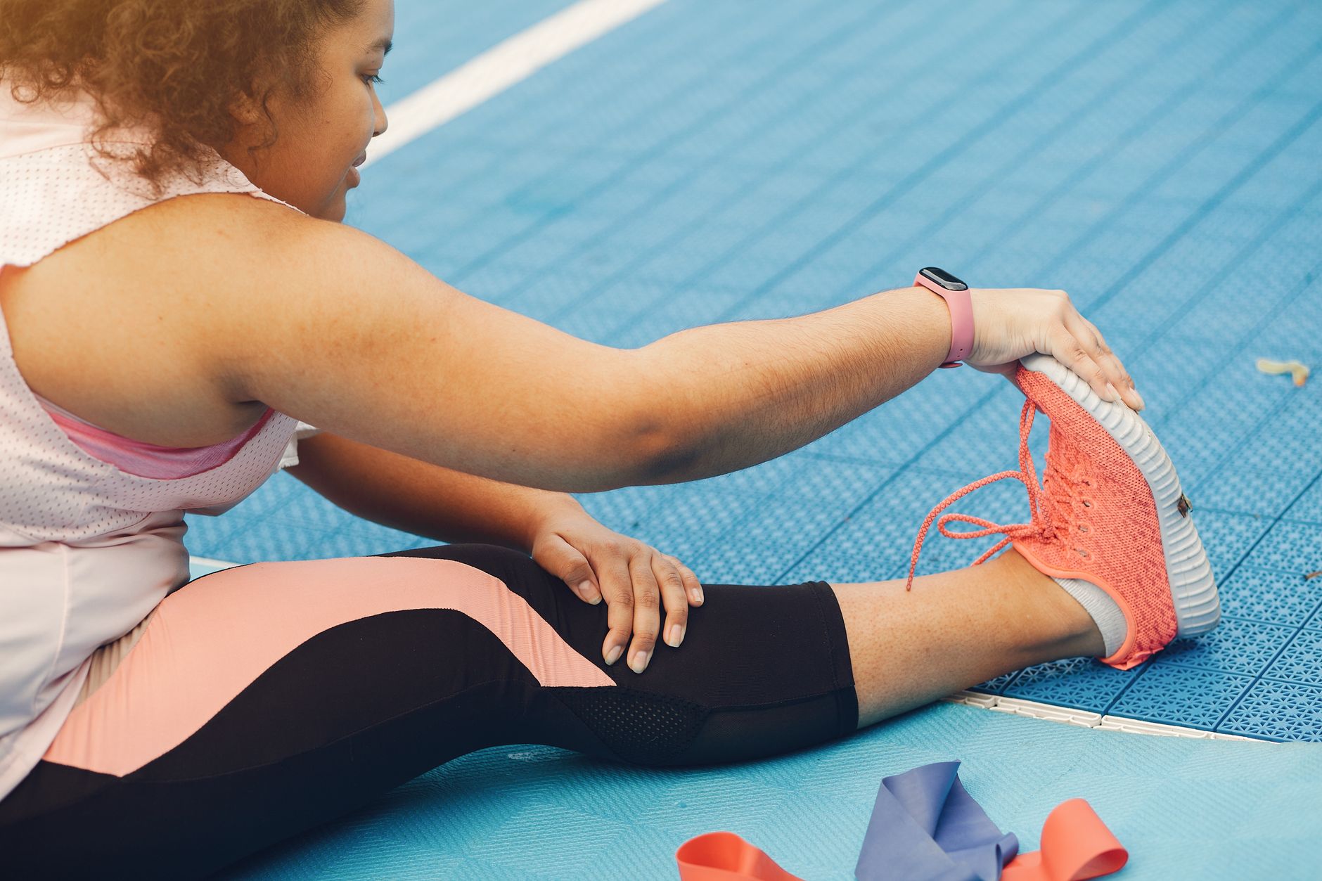 Spor sahasında bacağını esneten bir kişi