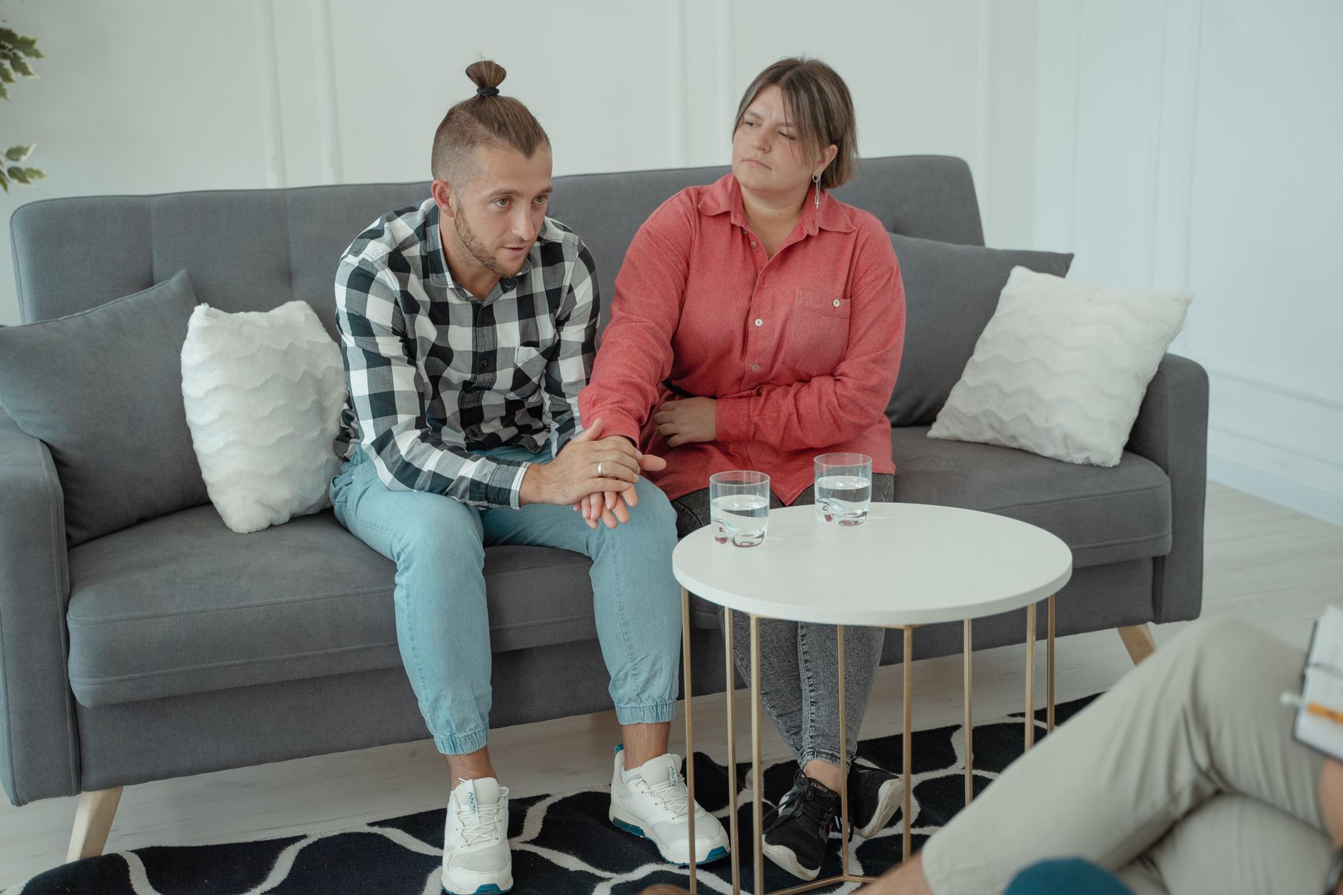 Kanepede el ele tutuşarak konuşan çift