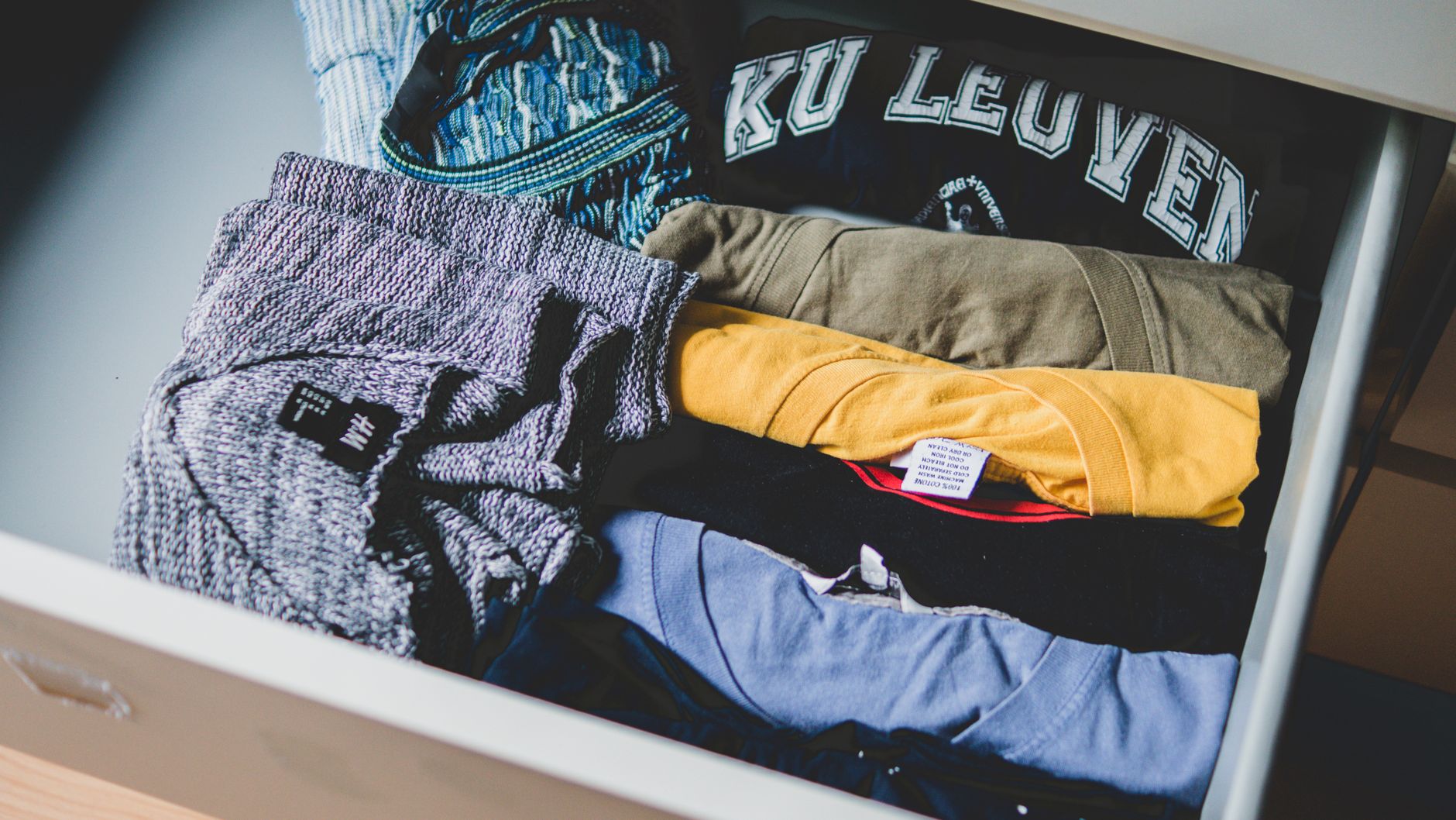 Bir çekmecede düzgünce katlanmış tişört ve giysiler