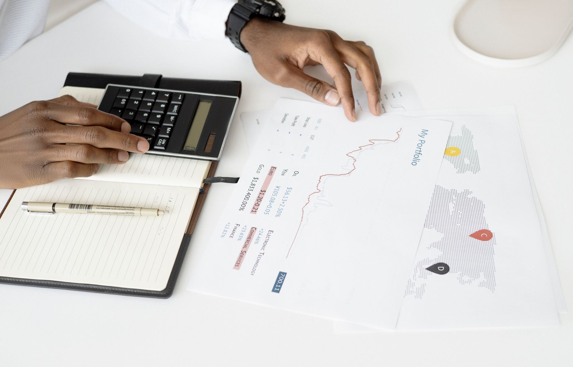 Bir kişinin hesap makinesiyle finansal belgeleri inceleyip yatırım planlaması yapması