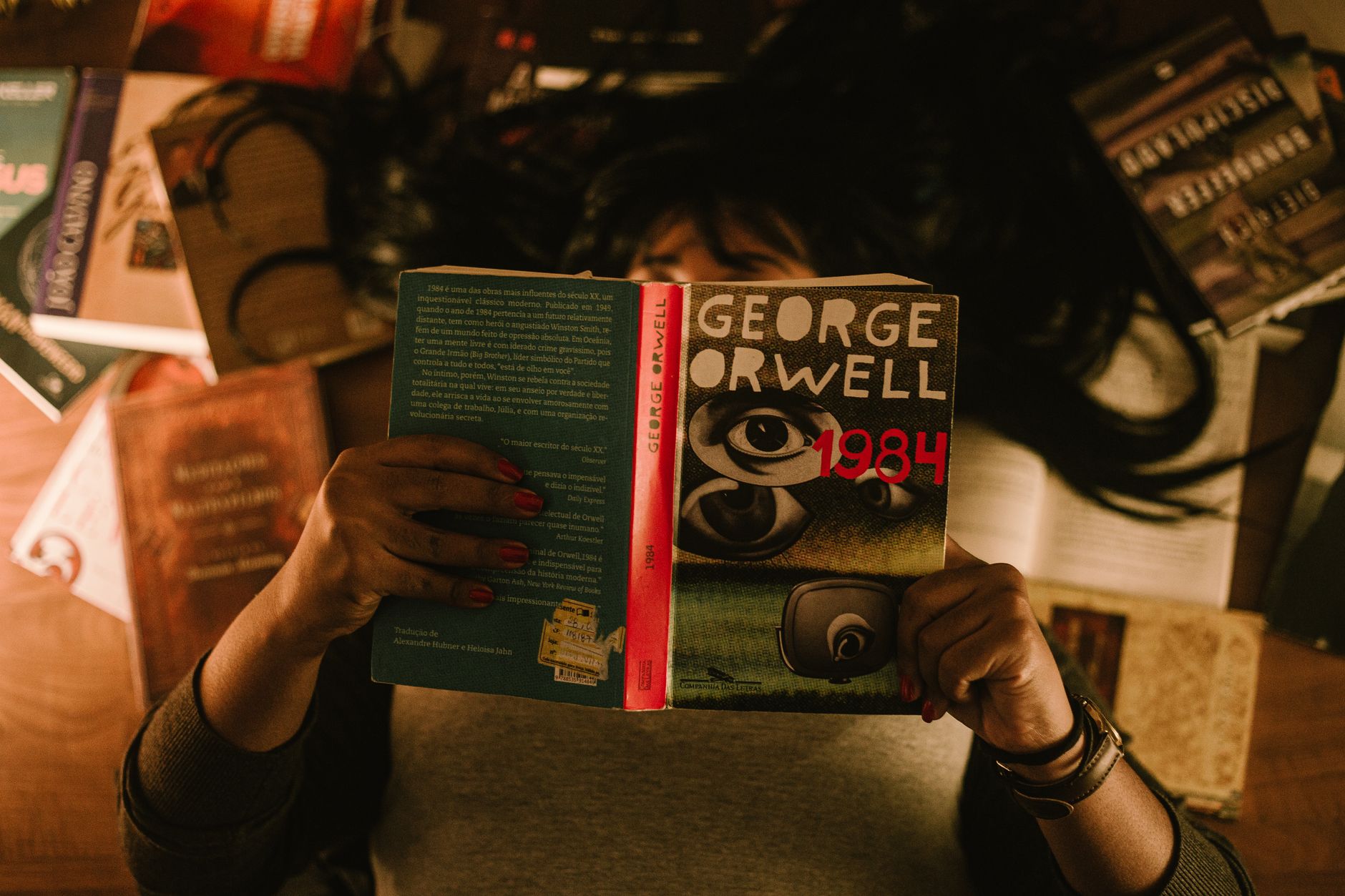 Elinde George Orwell'in 1984 romanını tutan ve okuyan bir kişi