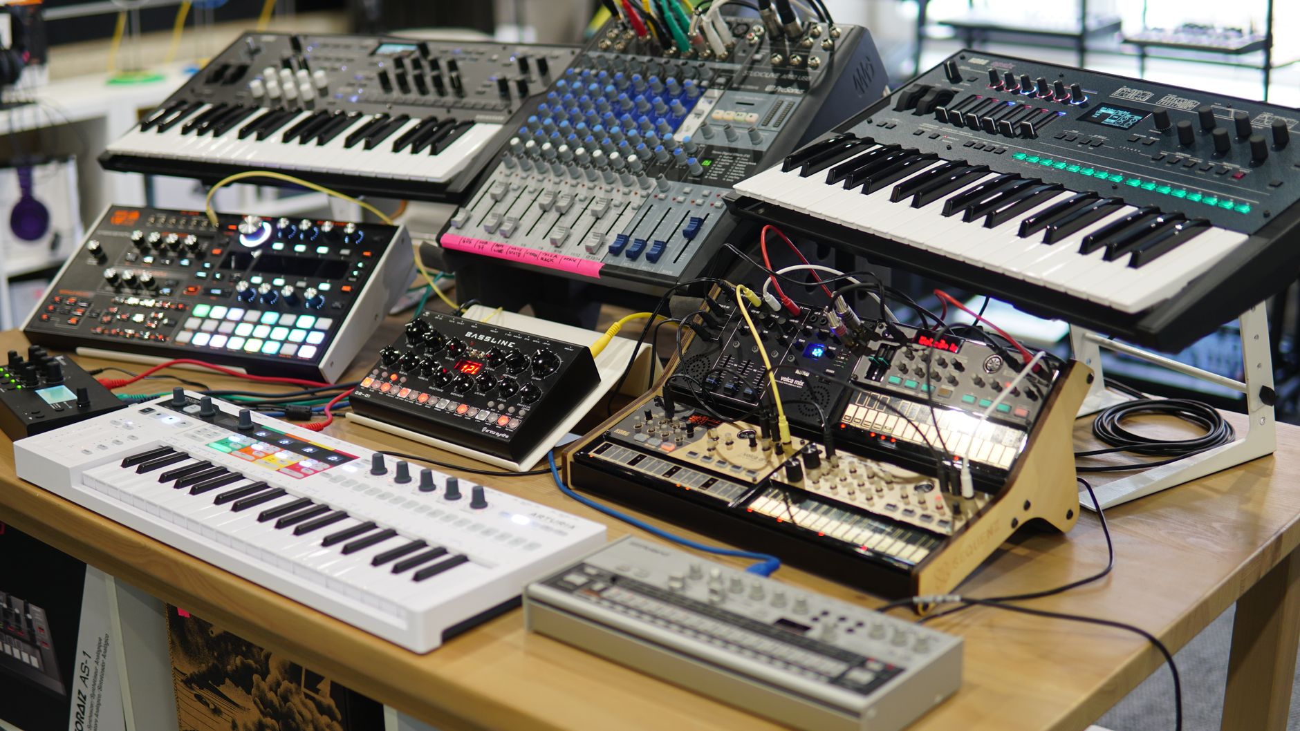 Ahşap bir masada synthesizer ve ses mikserlerinden oluşan elektronik müzik prodüksiyon ekipmanları